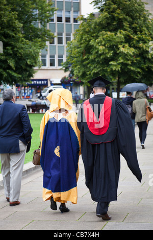 Étudiant diplômé promenades avec dame habillé en costume national africain au cours de l'Université de Bristol, l'obtention du diplôme de célébrations. Banque D'Images