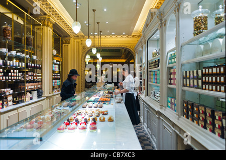 Paris, France, à l'intérieur du salon de thé Angelina, boulangerie française, femme de pâtisserie commis vendant des pâtisseries au comptoir Banque D'Images