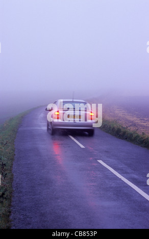 Antibrouillards pour voiture roulant à travers un épais brouillard on country road uk Banque D'Images