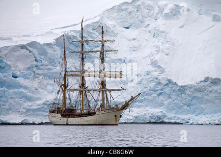 Le tallship / trois-Europa, un trois-mâts barque en face d'un glacier géant wall en Antarctique Banque D'Images