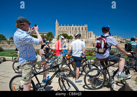VISITE DE PALMA MALLORCA un groupe de cyclistes s'arrête pour admirer la cathédrale de Palma dans le parc de la Mar Palma centre historique de Majorque Espagne Banque D'Images