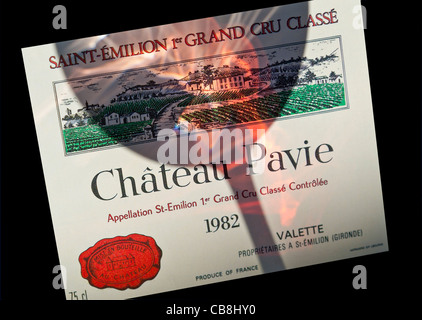 Château Pavie Dégustation de vin dans l'ombre, tourbillonnant en verre relevant de l'étiquette du Château Pavie 1982 Saint Emilion Grand Cru vin rouge Bordeaux France Banque D'Images