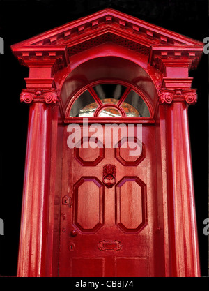 Entrée néo-gothique de rouge et porte sur fond sombre Banque D'Images