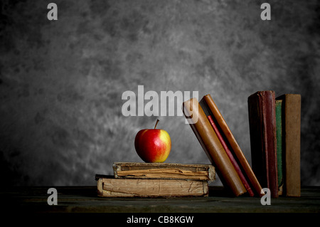 Une pomme et de vieux livres en lambeaux Banque D'Images