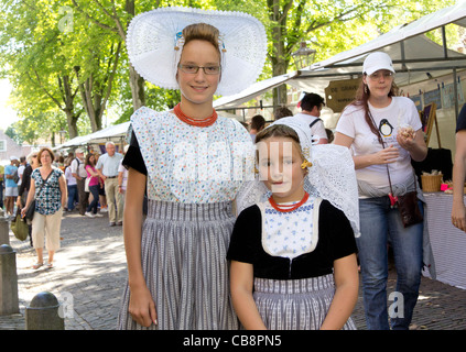 Photo de deux jeunes filles dans un costume traditionnel marché dans la ville de Veere - Walcheren, Zélande, Pays-Bas Banque D'Images