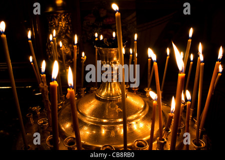 Photo de brûler des bougies à l'église avec fond sombre Banque D'Images