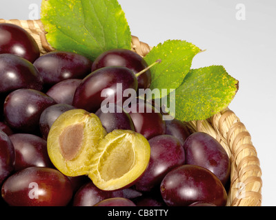 Un panier avec des prunes en gris retour Banque D'Images