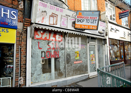 Un atelier, dans une banlieue de Londres high street avec 'fermeture vente' sur sa fenêtre et un conseil d'agents offrant un loyer réduit. Banque D'Images
