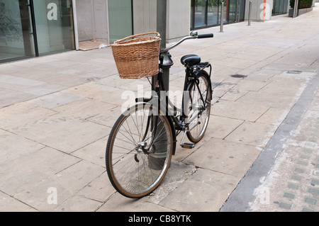 Vélo traditionnel avec un panier en osier appuyé contre un lampadaire Banque D'Images