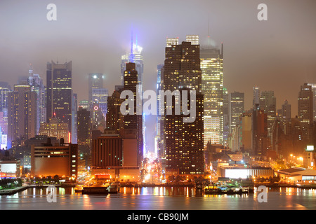 New York City Manhattan Midtown 42e rue horizon dans la nuit avec un gratte-ciel sur la rivière Hudson vue depuis le New Jersey. Banque D'Images