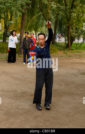 Homme du métier faisant des tours avec Yo Yo chinois dans zizhuyuan purple bamboo park à Beijing République populaire de Chine Banque D'Images