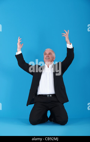Homme d'affaires sur ses genoux Banque D'Images