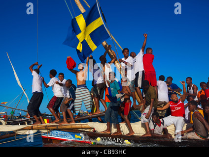 Sous pavillon suédois avec Dhow équipage qui agitait la main et encourager eux-mêmes, Maulidi, Lamu Kenya Banque D'Images