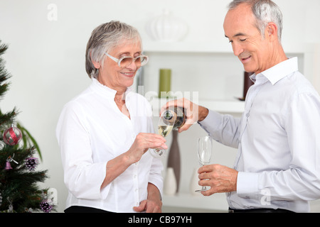 Vieux couple drinking champagne Banque D'Images