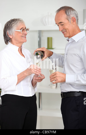 Man pouring Sparkling wine à sa femme Banque D'Images