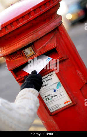 L'affichage d'une carte de Noël en rouge britannique post box en temps UK Banque D'Images