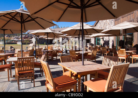 Patio extérieur restauration pour une station de montagne lodge avec parasols sur tables et chaises en bois Banque D'Images
