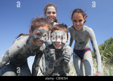 Enfants recouverts d'une boue curative jouer sur la plage, près de resort Tuzlata ville de Balchik, côte de la mer Noire, Bulgarie Banque D'Images