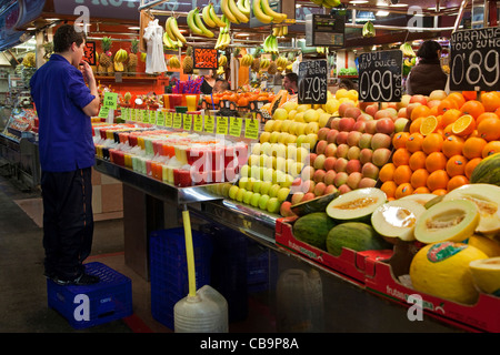 Man selling fruits frais au stand au marché de la Boqueria à Barcelone, Espagne Banque D'Images