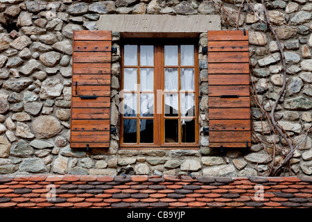 Fenêtre typique sur une maison construite en pierre avec des volets en bois en France Banque D'Images