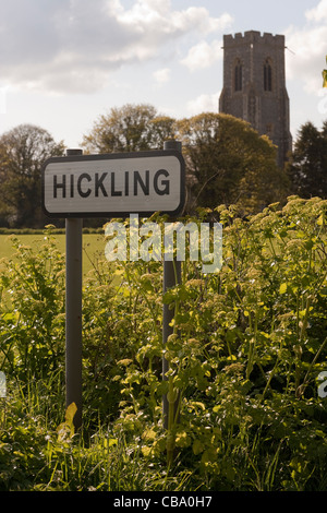 Hickling village road sign avec Alexandre en fleur. St Mary's Church tower dans le champ derrière. Printemps, Norfolk. Banque D'Images