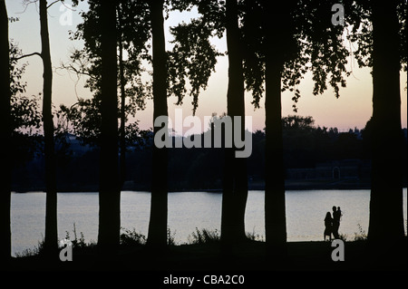La silhouette de la famille le long de la rive à la recherche au coucher du soleil avec bébé en transporteur à GreenLake Seattle Washington State USA Banque D'Images