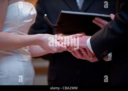 Un couple échange des anneaux de mariage alors qu'un script officiel de lecture vow Banque D'Images