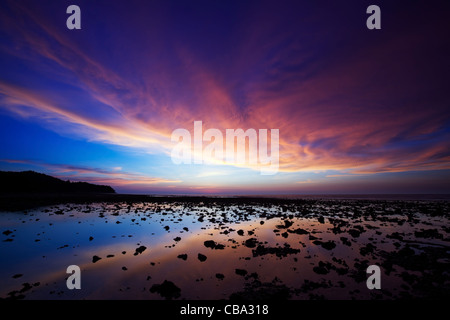 Spectaculaire coucher de soleil sur la côte rocheuse à Nai Yang Beach. L'île de Phuket, Thaïlande. Banque D'Images