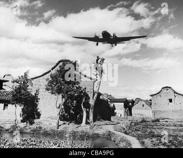 Un avion de transport C46 Commando survole un village de Chine, en route vers la Birmanie Banque D'Images