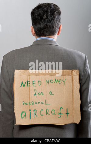 Homme avec un carton gris sur Besoin d'argent signe Banque D'Images