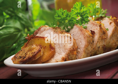 Morceaux de porc cuit sur plaque blanche avec le persil et les pommes de terre Banque D'Images