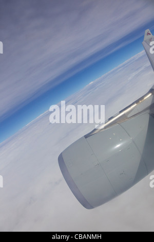 Vue à travers la fenêtre du passager jet avion de Qatar, aile Ciel et nuages Banque D'Images