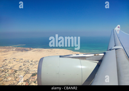 Vue à travers la fenêtre du passager jet avion de Qatar, aile Ciel et nuages Banque D'Images