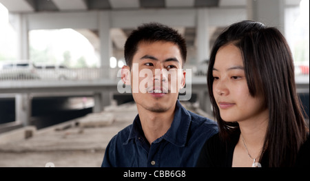 Jeune couple assis et de parler sous un pont Banque D'Images