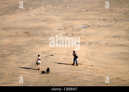 Dog walking Crantock Beach sur la côte nord des Cornouailles Banque D'Images