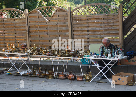 Un homme de vente de divers articles en laiton vintage sur l'étal du marché aux puces. Lagow, l'ouest de la Pologne. Banque D'Images