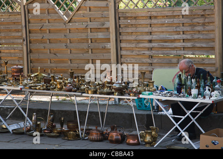 Un homme de vente de divers articles en laiton vintage sur l'étal du marché aux puces. Lagow, l'ouest de la Pologne. Banque D'Images