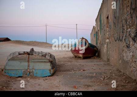 Vieux bateaux de pêche pose à côté d'un bâtiment abandonné Banque D'Images