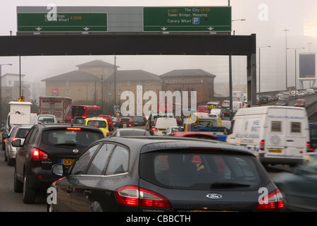 Queues de véhicules se déplaçant dans les Docklands de Londres durant l'heure de pointe du matin d'un jour brumeux Banque D'Images
