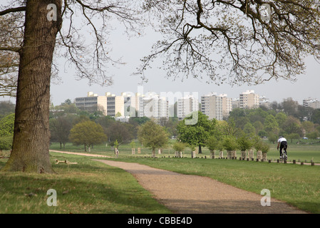 Le dirigeant d'une cycliste à Richmond Park, au sud-ouest de Londres, montrant vacances bocks de Roehampton, dans l'arrière-plan Banque D'Images