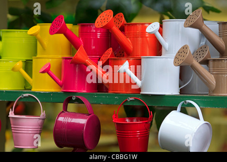 Arrosoirs métal coloré en vente dans une boutique de fleuriste Banque D'Images