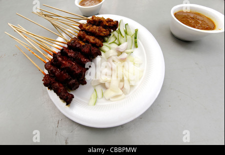 Mouton et poulet satay sur des bâtons avec le concombre et la sauce arachide fondée en vente dans Lau Pa Sat, Singapour Banque D'Images