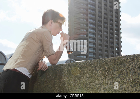 Man drinking soda sur balcon Banque D'Images