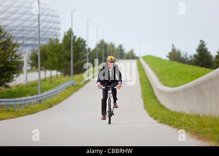 Woman riding bicycle in urban park Banque D'Images