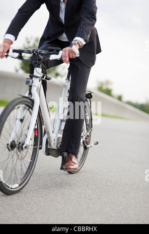 Woman riding bicycle in urban park Banque D'Images