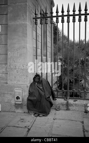 Les sans-abri en forme de bourse du jardin des plantes., dormir assis au pied de pikes. Banque D'Images