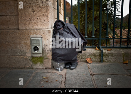 Les sans-abri en forme de bourse du jardin des plantes., dormir assis, et caché. Banque D'Images