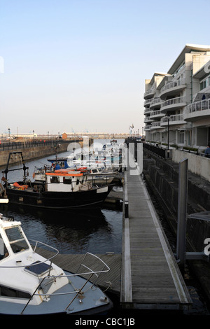 Des bateaux amarrés dans l'ancien quai à gravis, baie de Cardiff, pays de Galles, le long des appartements modernes Banque D'Images