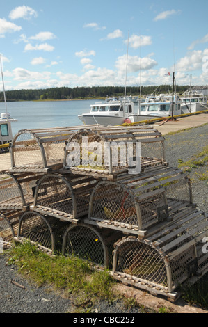 Les casiers à homards grace le premier plan comme les bateaux de pêche sont liés aux quais dans le port de North Lake Harbour, Î. Banque D'Images