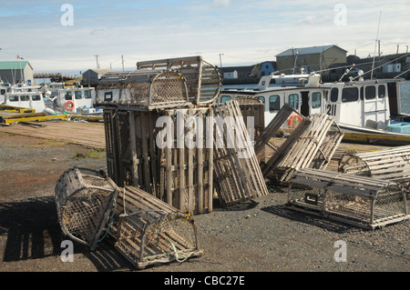 Les casiers à homards grace le premier plan comme les bateaux de pêche sont liés aux quais dans le port de North Lake Harbour, Î. Banque D'Images